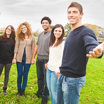 Group of five people holding hands, outdoors, welcoming someone into our substance abuse treatment centers in Orange County, CA