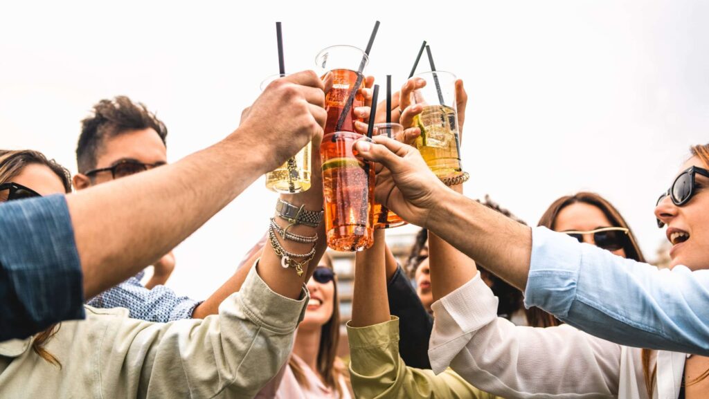 A group of young people are in a circle raising their glasses of alcohol together wonders how to flush alcohol from their urine after a drinking.