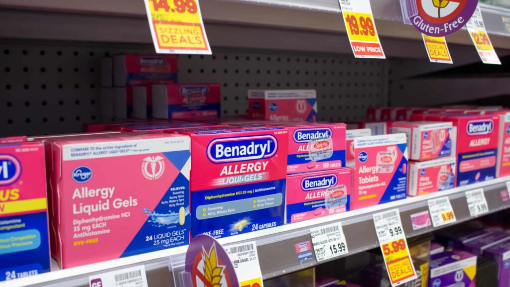 A row of Benadryl and other allergy medications on a store shelf makes users question is Benadryl addictive?