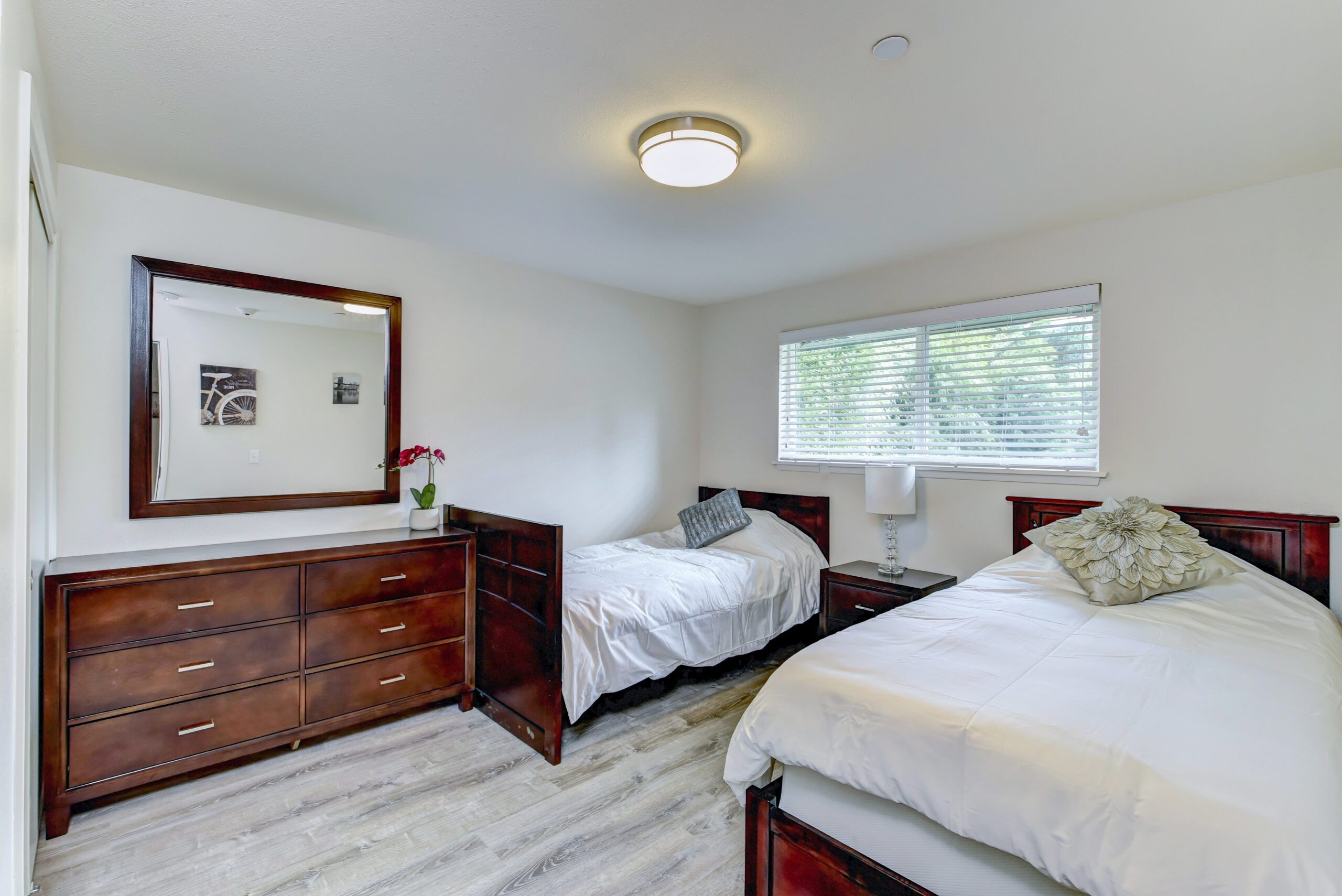 Two beds with white comforters and brown headboards in women's rehab center