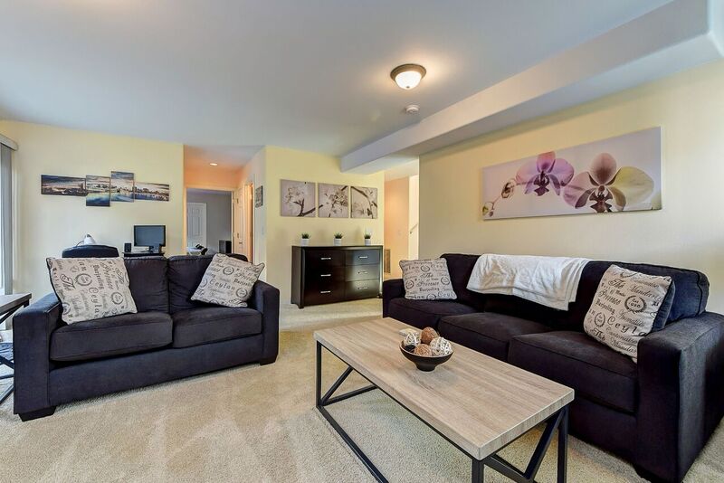 Living room with dark gray couches, colorful wall art, and brown table in addiction family program