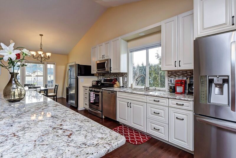 Kitchen with gray countertops and white cabinets facing window in inpatient rehab in Washington state