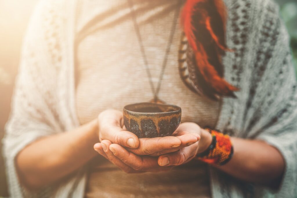 A female is holding a small bowl with both hands containing the psychoactive substance DMT, which begs the question of how long does DMT last?