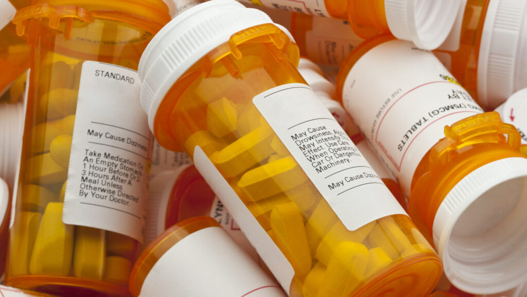 A pile of orange pill bottles filled with tramadol raises the question of how long does tramadol stay in your system.