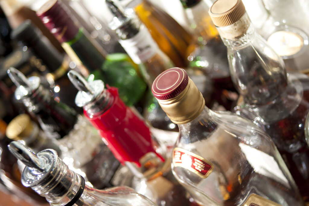 Various bottles of liquor and alcohol are lined up and costs more in total compared to seeking out the cost of alcohol rehab.