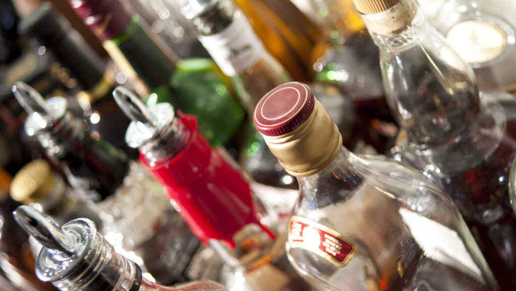 Various bottles of liquor and alcohol are lined up and costs more in total compared to seeking out the cost of alcohol rehab.