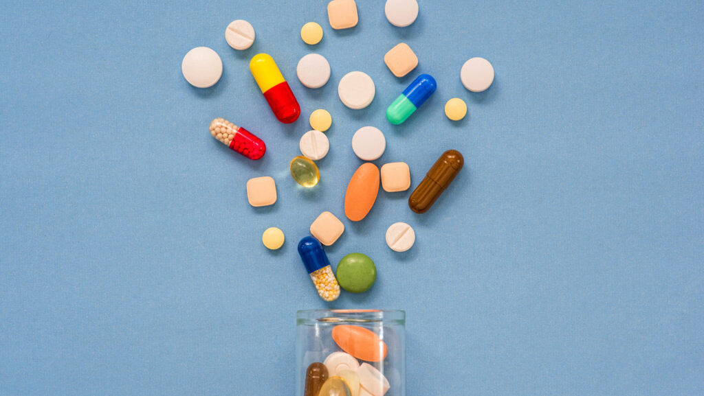 A clear bottle is spilled out with various different medications representing the first step of treatment in detox.