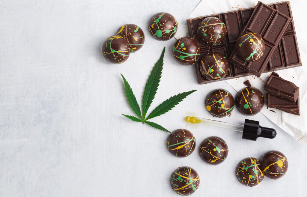 Cannabis infused chocolate edible candies spread out on a white table can vary in how long edibles last in the system.