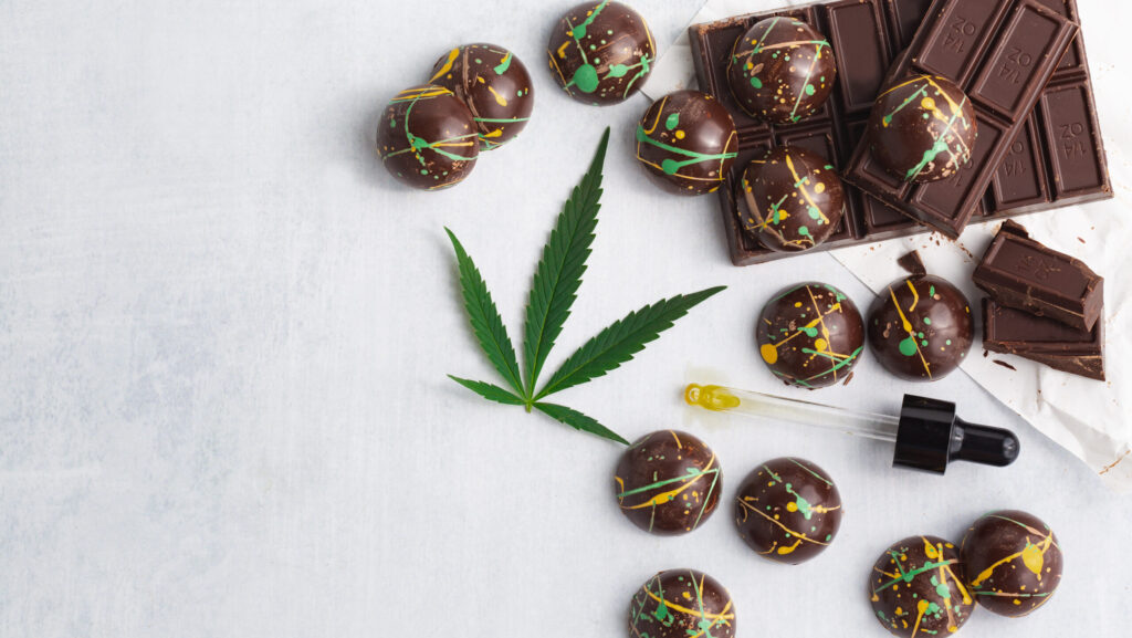 Cannabis infused chocolate edible candies spread out on a white table can vary in how long edibles last in the system.