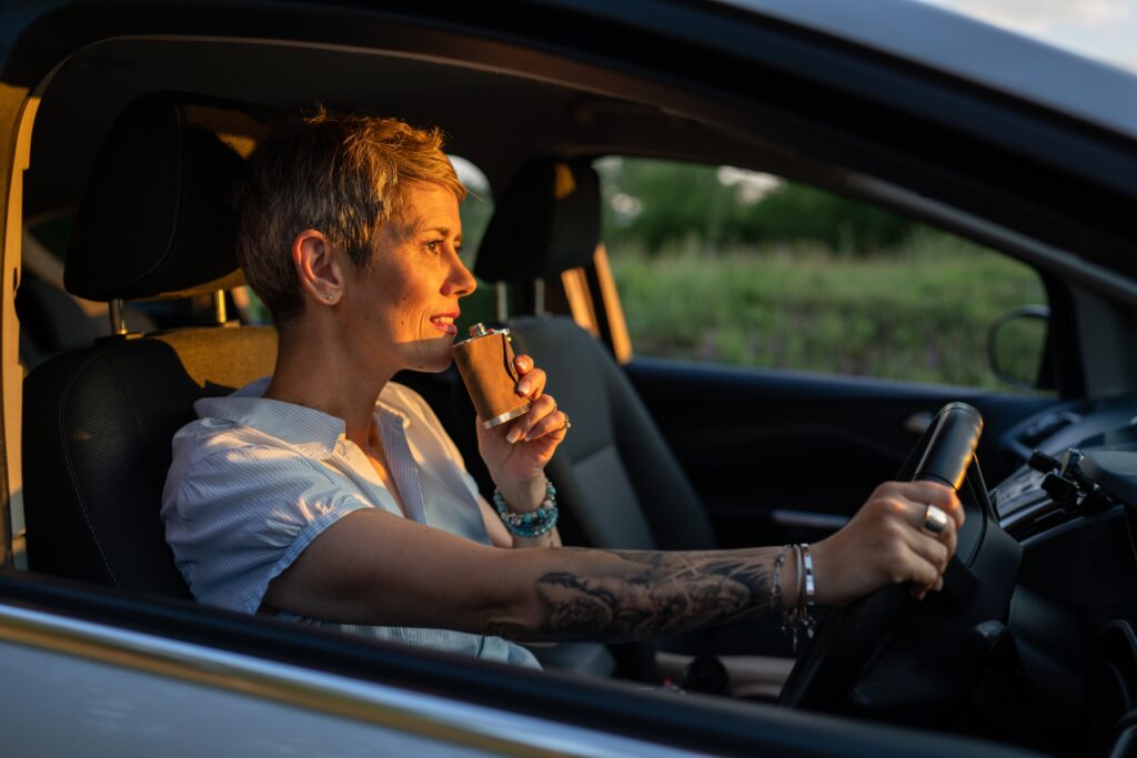 A woman holding a alcoholic flask and driving a car is a good way to spot an alcoholic female.