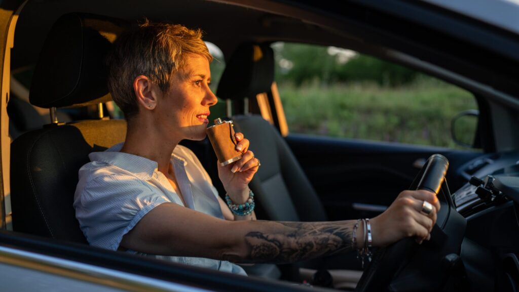 A woman holding a alcoholic flask and driving a car is a good way to spot an alcoholic female.