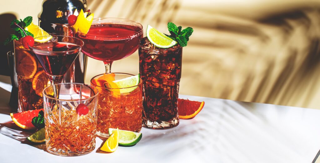 A variety of cocktail drinks sitting on a table represents how to flush alcohol out of your system.