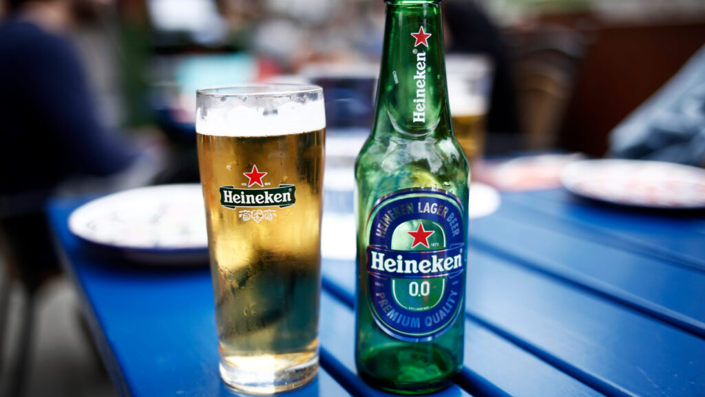 Heineken non alcoholic free beer on a blue picnic table.