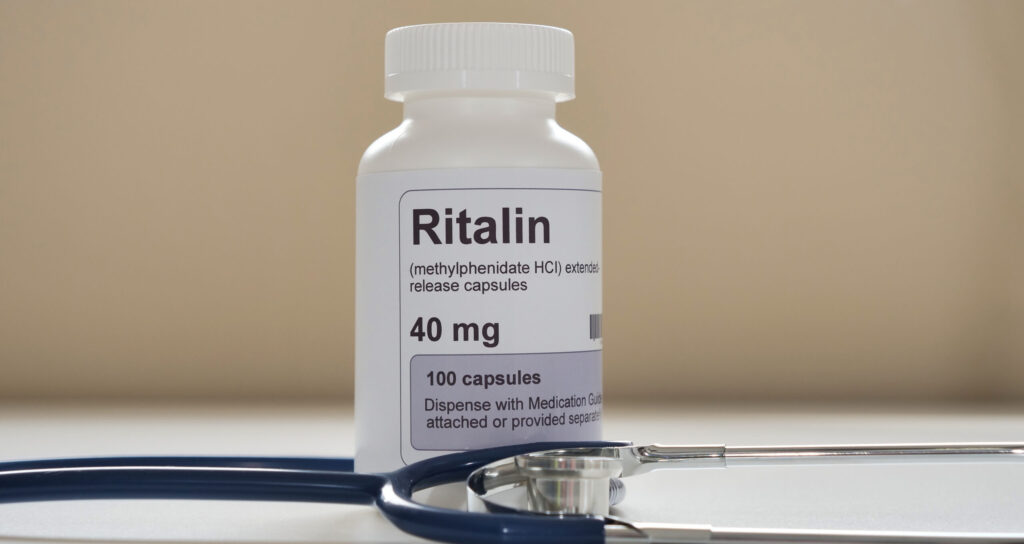 A prescription bottle of Ritalin next to a stethoscope represents the symptoms Ritalin withdrawal.