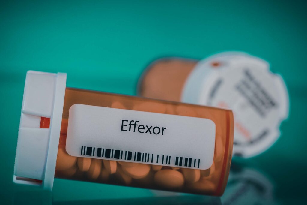 An orange bottle of prescription Effexor laying on the table.