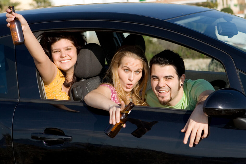 A groups of teens in a car holding beer bottles represents the effects of underage drinking on the brain.