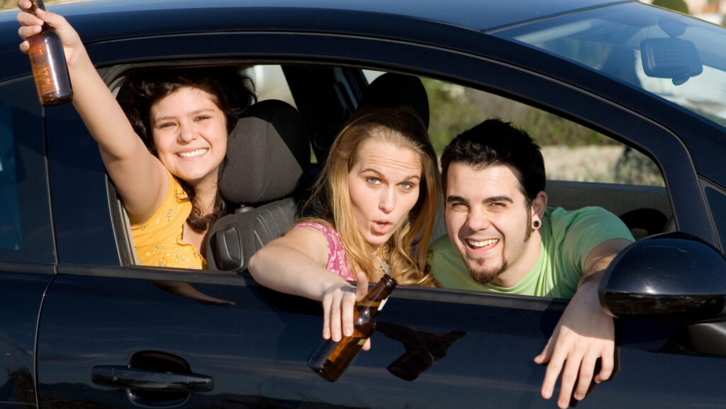 A groups of teens in a car holding beer bottles represents the effects of underage drinking on the brain.